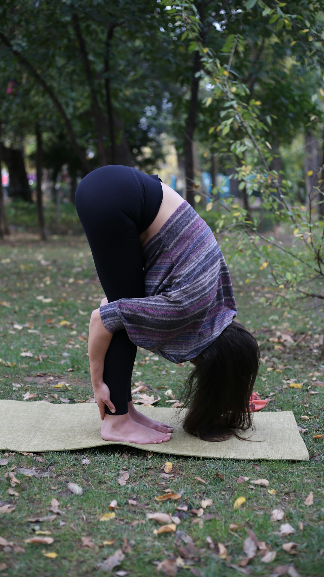 Offerings a-woman-doing-a-yoga-pose-in-a-park-1bbovwosjki