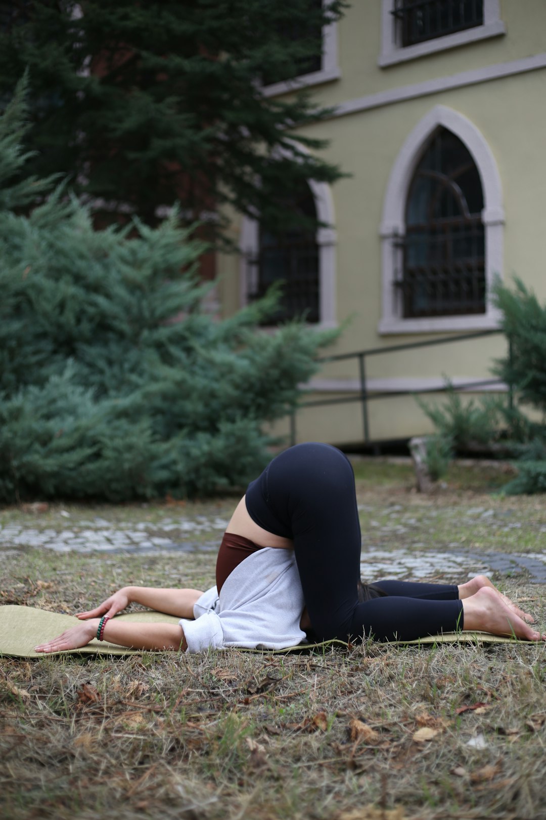Offerings a-woman-laying-on-a-yoga-mat-in-front-of-a-building-t3kwkp-of38